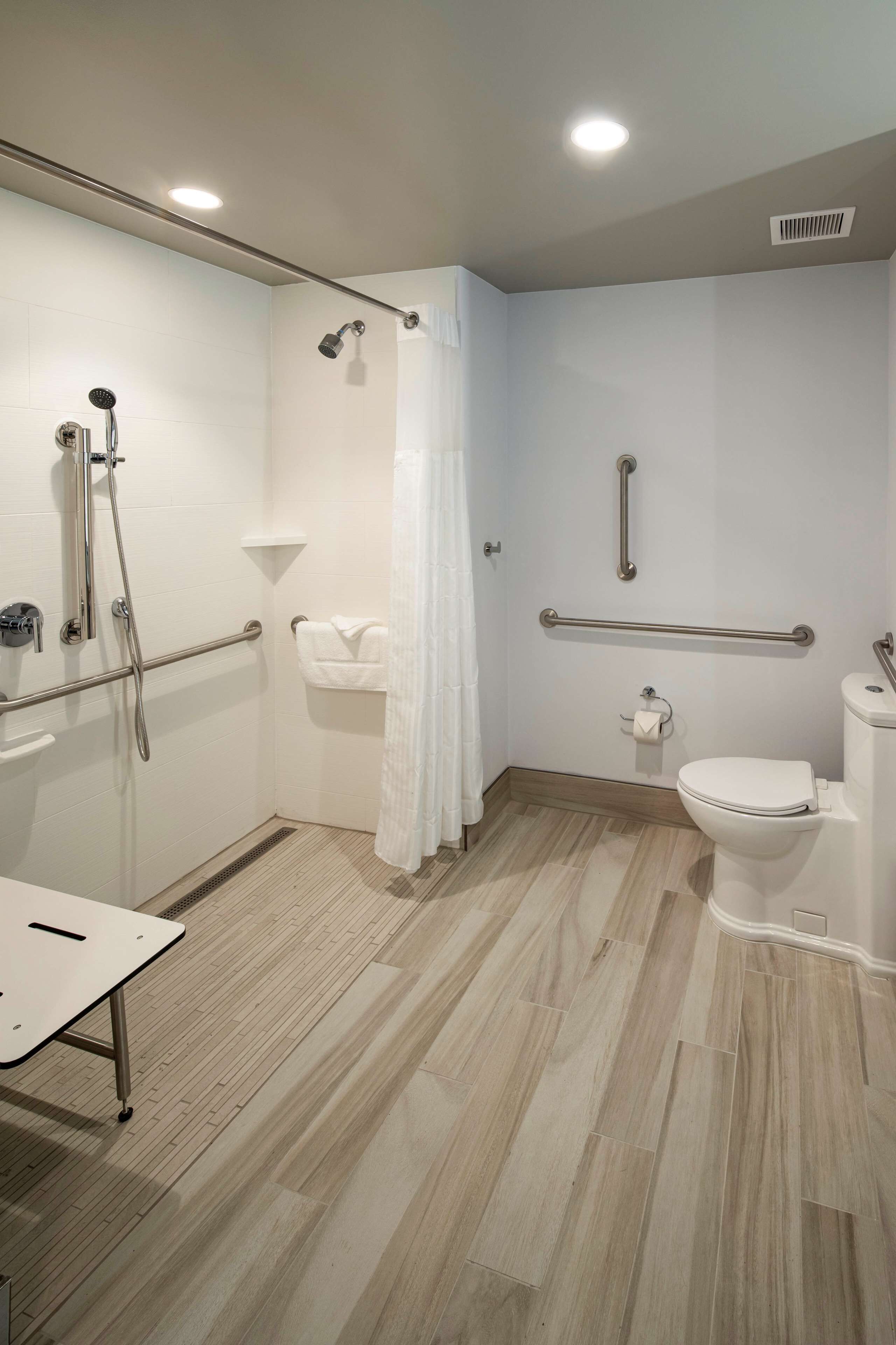 A modern bathroom with a shower, toilet, and sink.