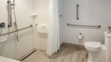 A modern bathroom with a shower, toilet, and sink.