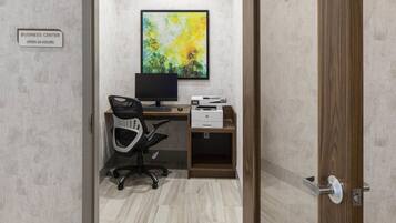A business center with a computer, printer, and office chair.