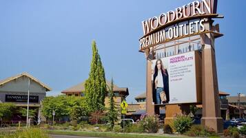 A Woodburn Premium Outlets sign with a large billboard advertising discounts.