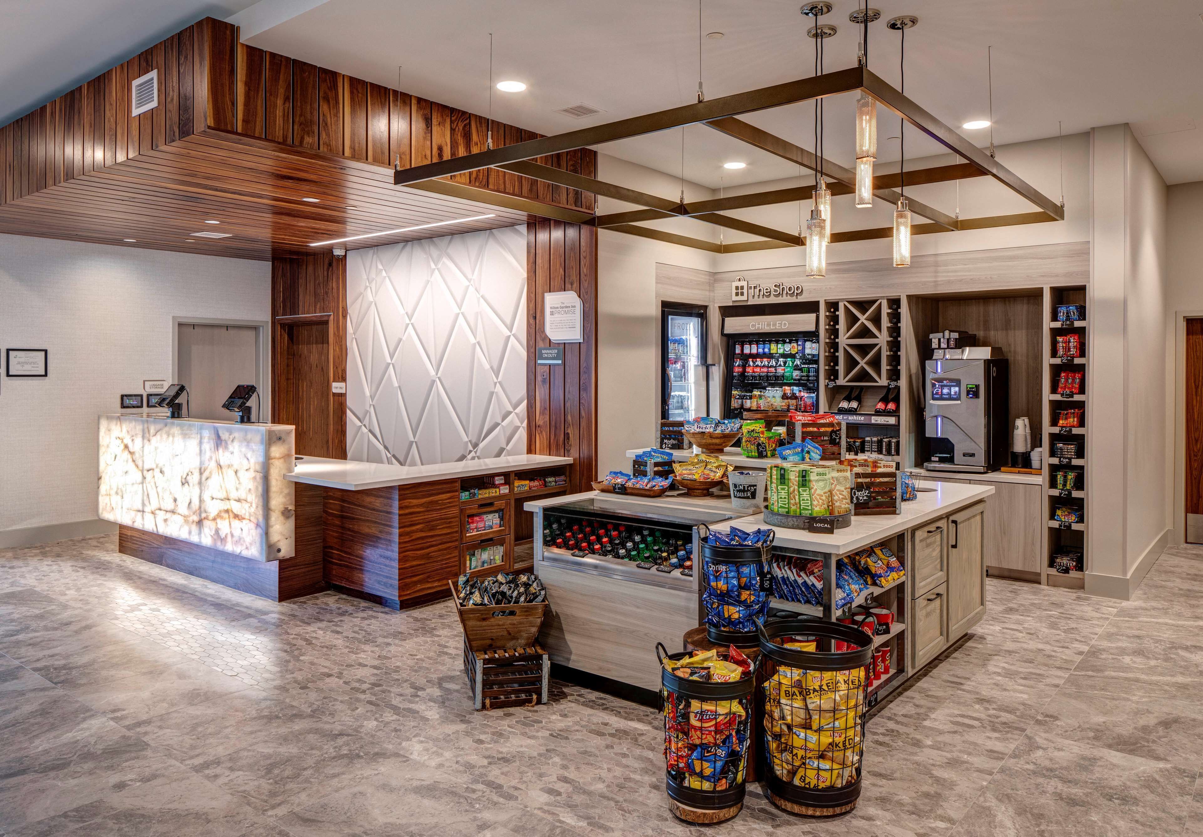 A reception area with a wooden reception desk, a counter with snacks, and a refrigerated display.