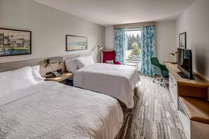 A hotel room with two beds, a desk with a computer, a TV, and a window with curtains. - Hilton Garden Inn Wilsonville Portland (Wilsonville)