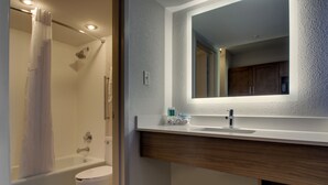 Ein modernes Badezimmer mit Badewanne, Toilette und Waschtisch mit Spiegel.