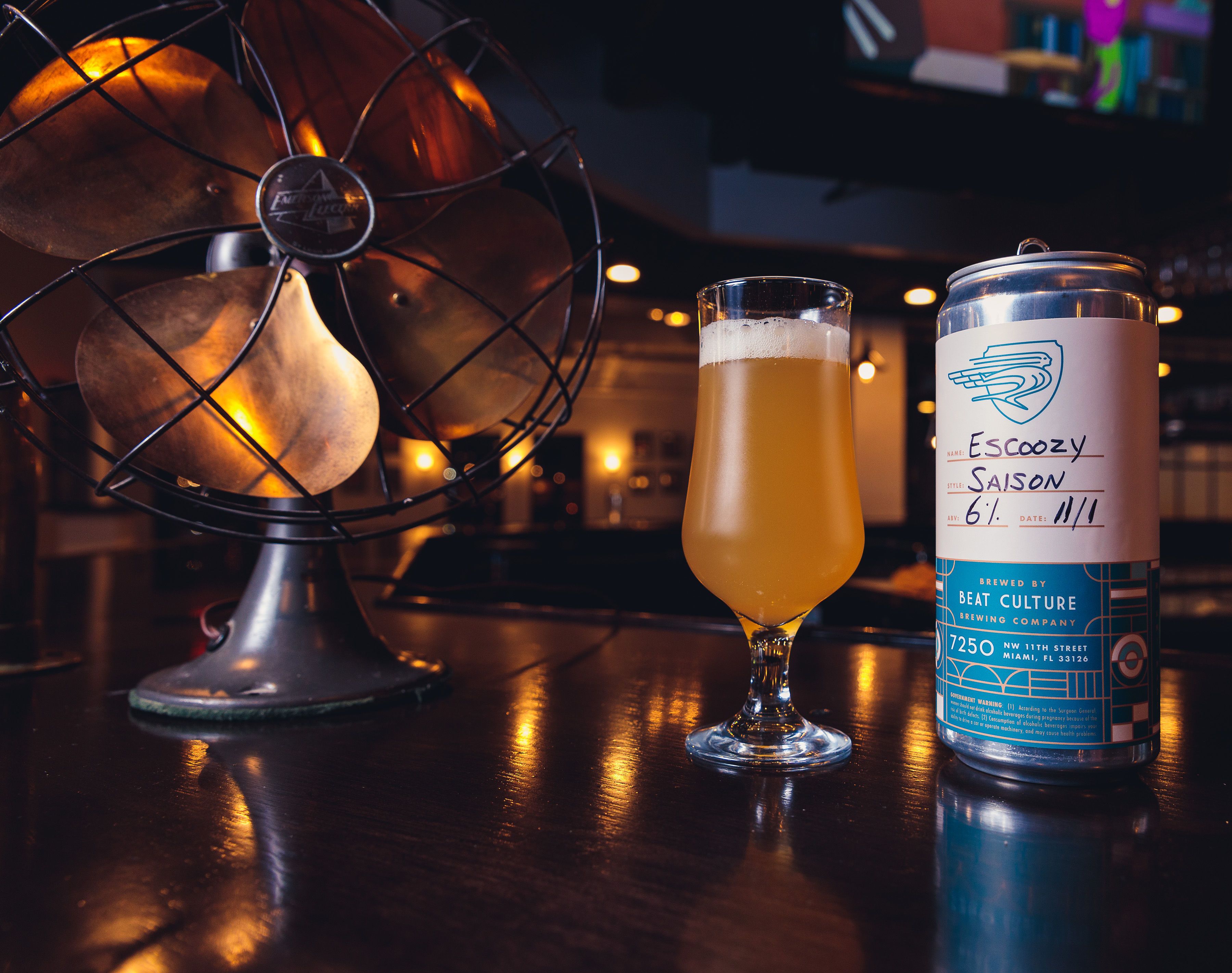 Ein Glas Bier und eine Dose Bier auf einer Bar.