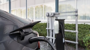 A car charging at a station with a building in the background. - enVision Hotel Miami International Airport (Miami)