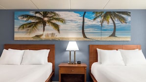 A hotel room with two beds, a nightstand with a lamp, and a beach-themed wall mural. - enVision Hotel Miami International Airport (Miami)