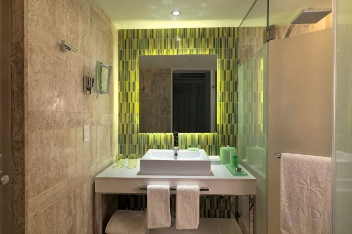 A bathroom with a white sink, mirror, and towel rack.