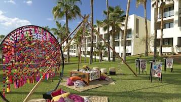 Guests can enjoy a tranquil atmosphere amidst lush greenery and palm trees.