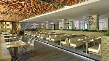 Restaurante moderno com painéis de teto de madeira, mesas comunitárias grandes e cabines.