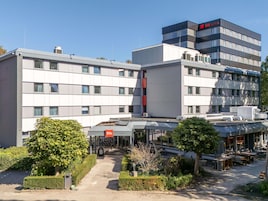 Un hotel moderno con entrada principal, zona de estar al aire libre y aparcamiento.