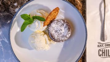 A dessert plate with ice cream and a powdered dessert on a marble table.