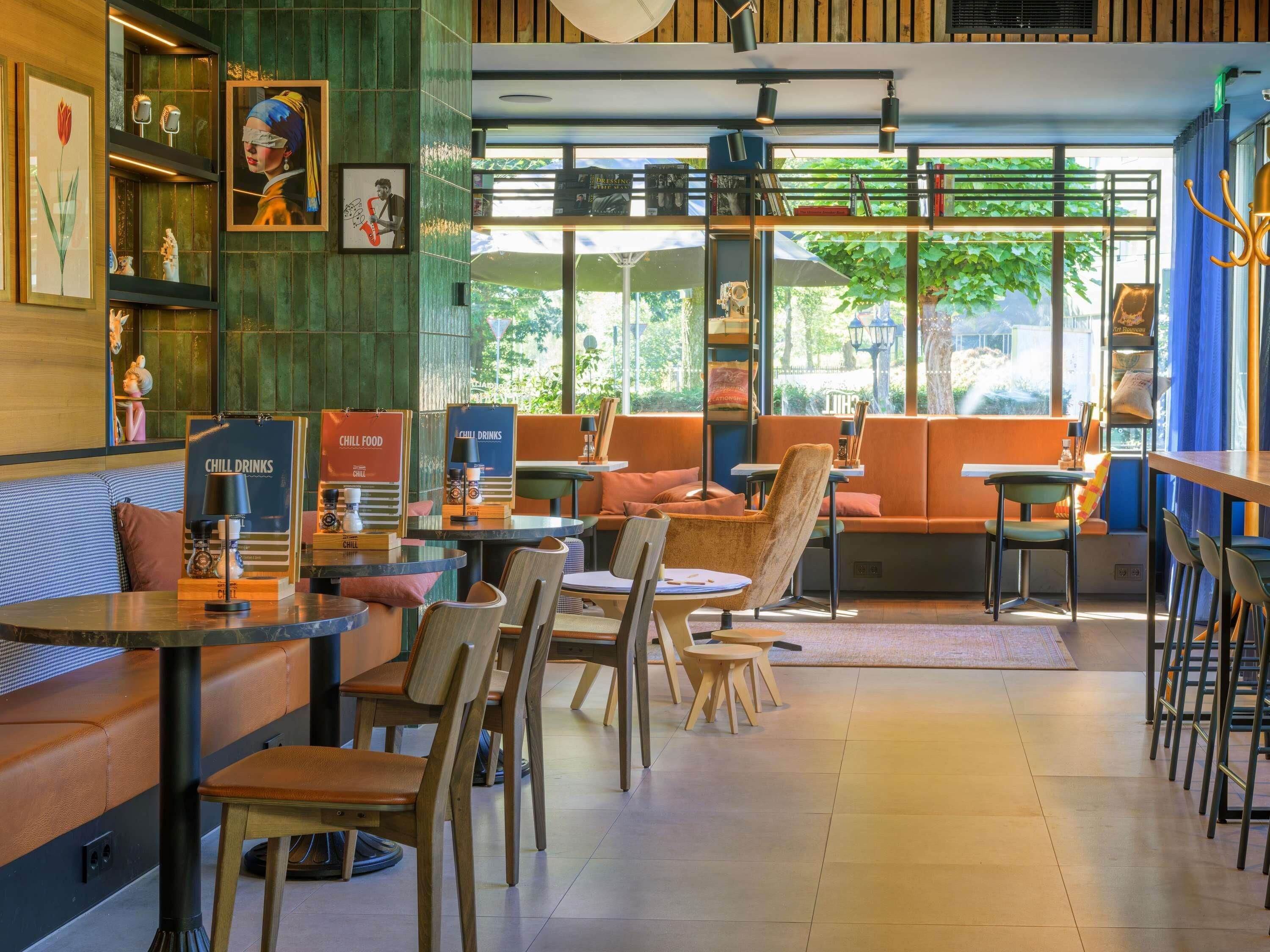 A cafe with seating arrangements, a coffee machine, and a menu board.