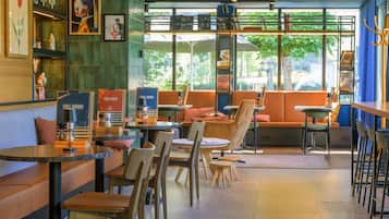 A cafe with seating arrangements, a coffee machine, and a menu board.