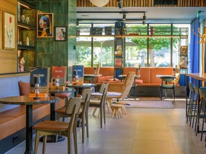 A cafe with seating arrangements, a coffee machine, and a menu board. - ibis Tilburg (Tilburg)
