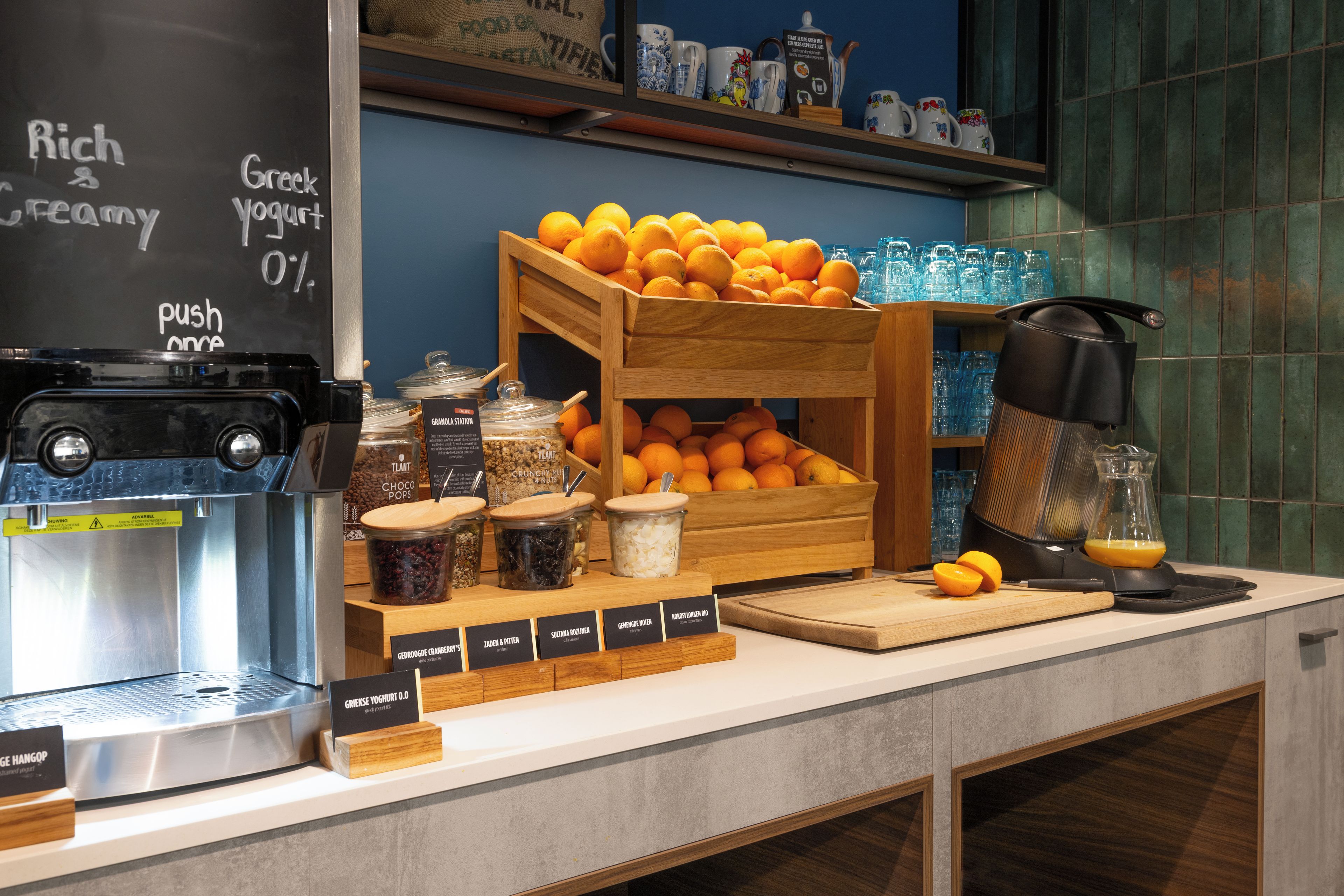 Una barra de desayuno con diversas opciones de comida, como naranjas, granola y yogur.