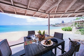 A table set for two with a view of the beach and ocean. - Hawksbill Resort Antigua (St. John's)