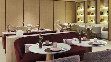 Ein modernes Restaurant mit runden Tischen, gepolsterten Sitzplätzen und einem warmen, holzigen Ambiente.
