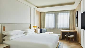 Una camera d'albergo con un letto grande, una scrivania, una sedia e una TV.