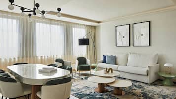 A modern living room with a round dining table, a sofa, and a coffee table.