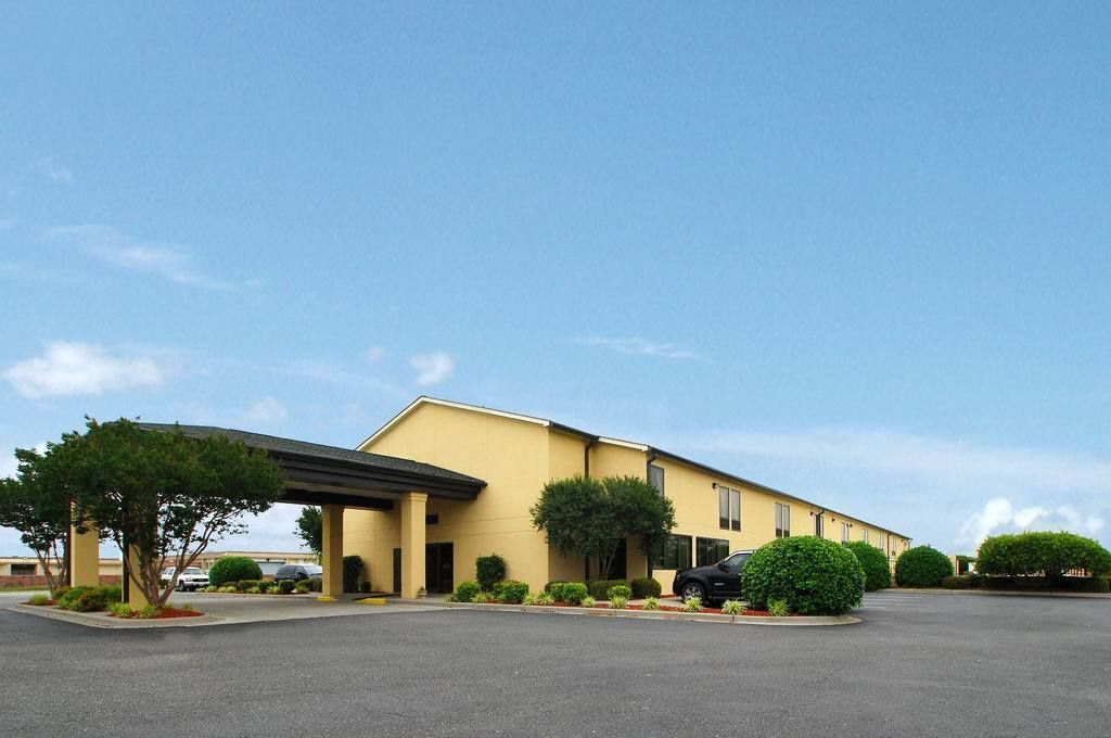 A two-story building with a flat roof and a covered entrance.