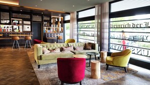 Un espace de détente moderne comprenant un canapé, des fauteuils et un bar.