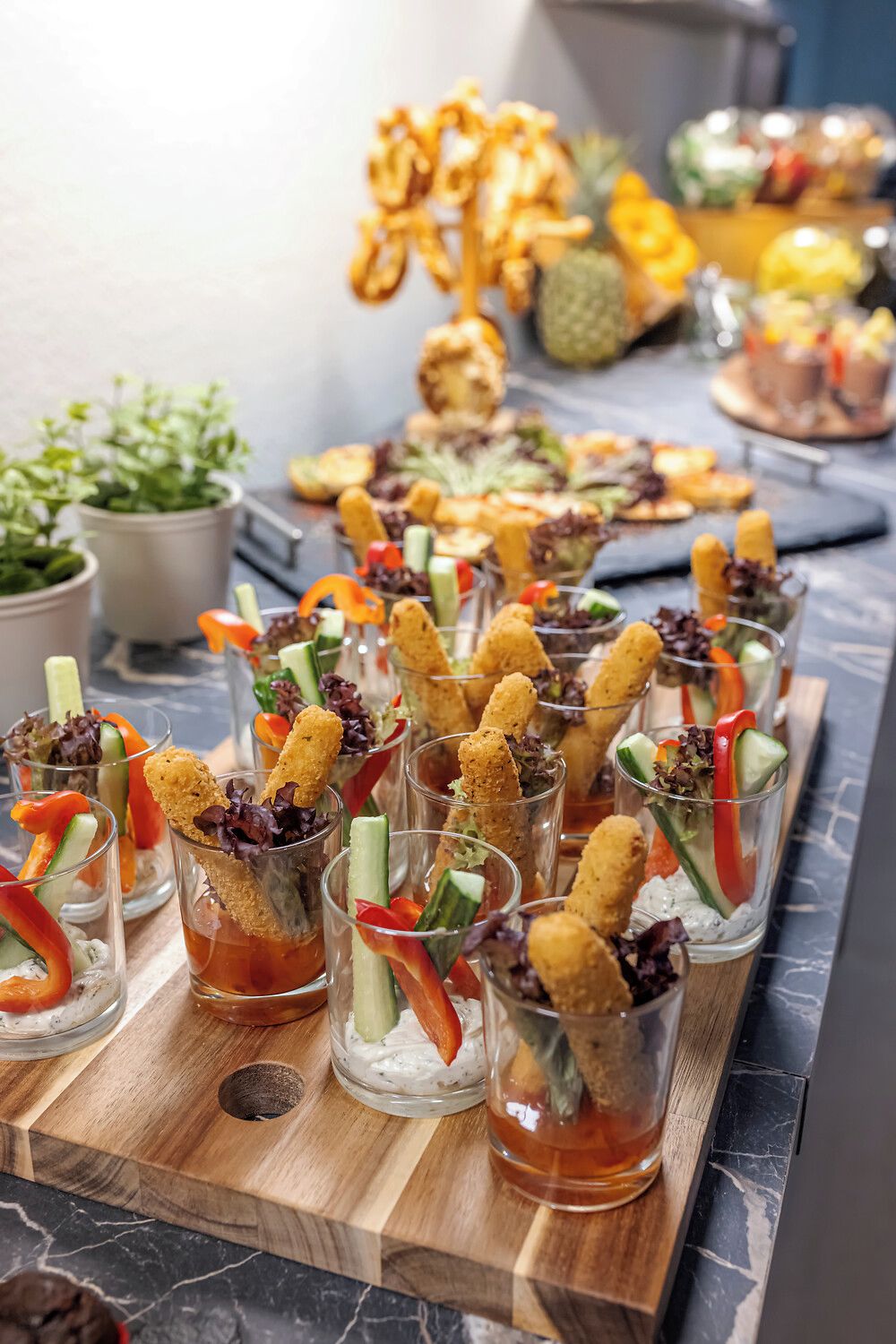 Una tabla de madera con alimentos, incluyendo aperitivos y bebidas.