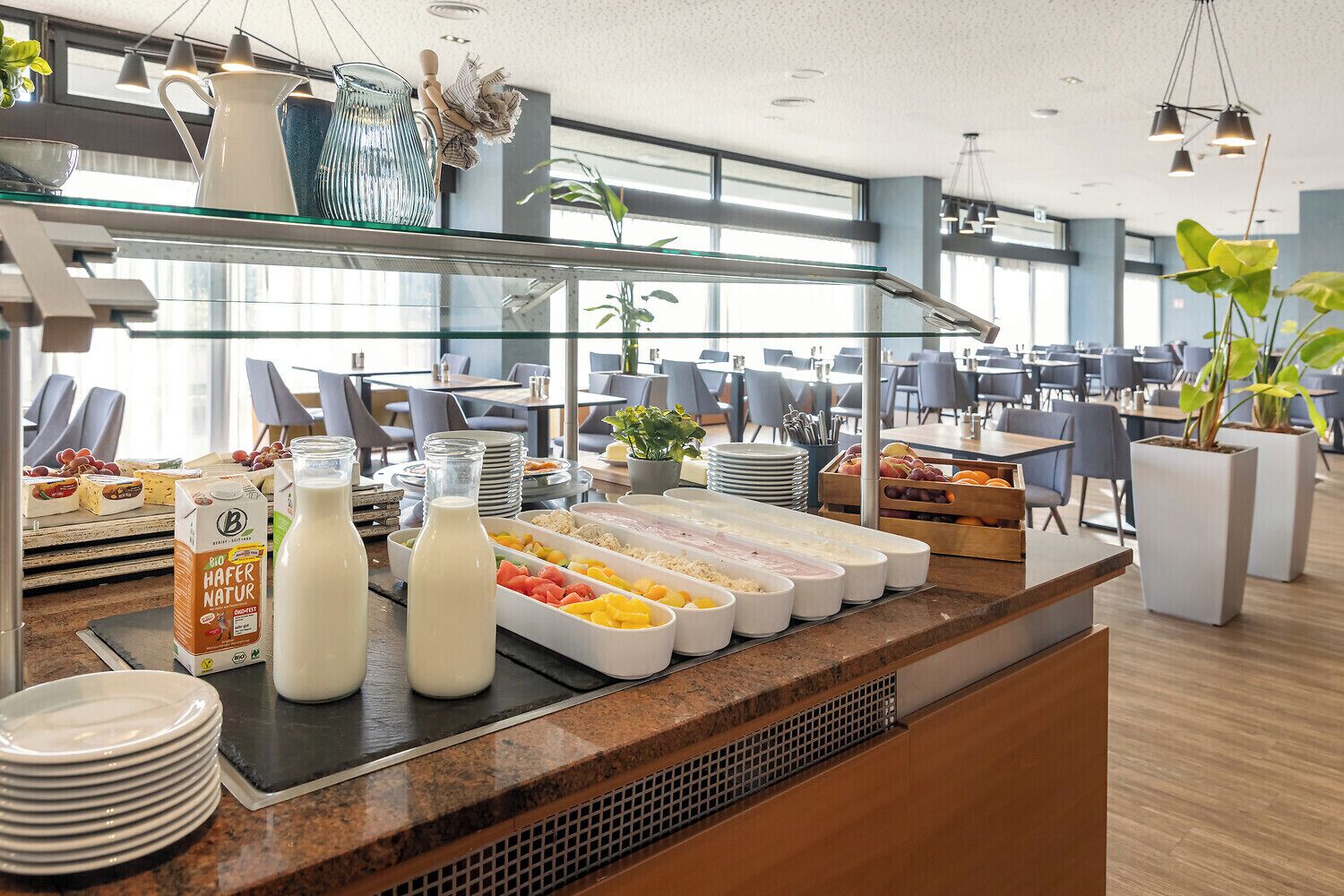 Un buffet proposant une variété de plats, des briques de lait et une vitrine réfrigérée dans un espace de restauration moderne.