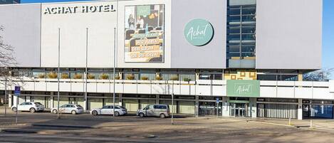 A modern hotel building with a prominent sign reading 'Achat Hotel.'