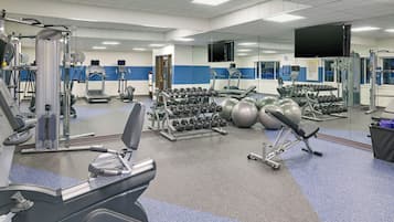 A gym with various exercise equipment, including treadmills, dumbbells, and exercise balls.