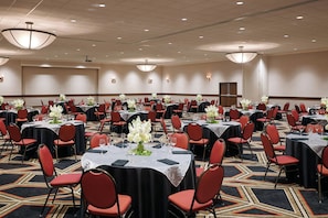 A large conference room with multiple tables, red chairs, and floral centerpieces. - Four Points by Sheraton Bellingham Hotel & Conference Center (Bellingham)