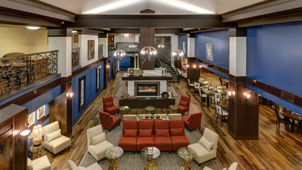 A spacious lobby with a fireplace, red sofas, and a staircase leading to upper floors. - Four Points by Sheraton Bellingham Hotel & Conference Center (Bellingham)