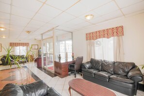 A spacious lobby with a leather sofa, a reception desk, and a glass partition. - Hotel O Grand Inn Channelview I-10 (Channelview)