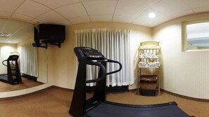 A fitness room with a treadmill, exercise mat, and a shelf with towels. - Holiday Inn Express Hotel & Suites Harriman by IHG (Harriman)