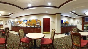 A hotel lobby with a curved reception desk, several round tables with chairs, and a patterned carpet. - Holiday Inn Express Hotel & Suites Harriman by IHG (Harriman)