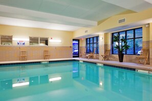 An indoor swimming pool with clear water, wooden lounge chairs, and large windows. - Holiday Inn Express Hotel & Suites Harriman by IHG (Harriman)