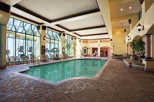 Una piscina techada, sillones reclinables de piscina