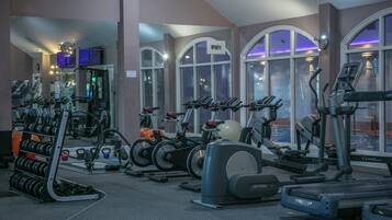 A gym with treadmills, stationary bikes, and weight machines.