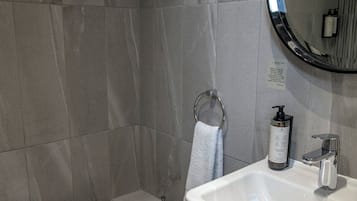 A modern bathroom with a toilet, sink, and mirror.