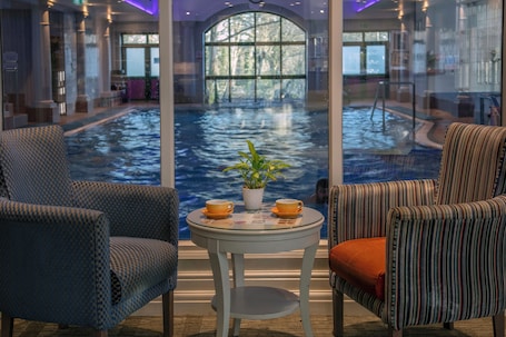 Una piscina techada, sillones reclinables de piscina