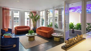 A modern living room with a sofa, armchairs, and a coffee table. - Hotel de la Poste – French Quarter, A Renaissance Hotel (New Orleans)