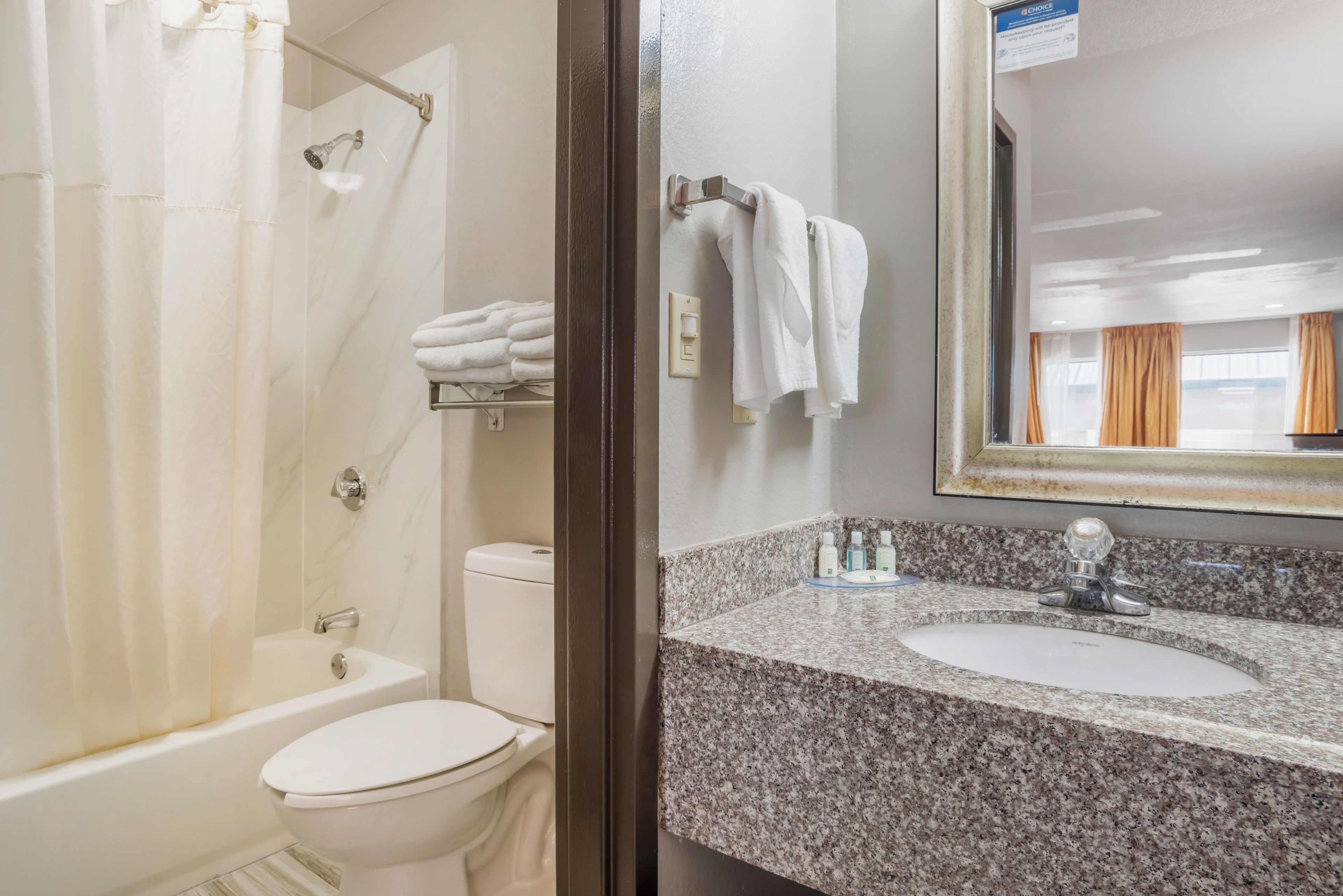 A bathroom with a shower, toilet, and sink.