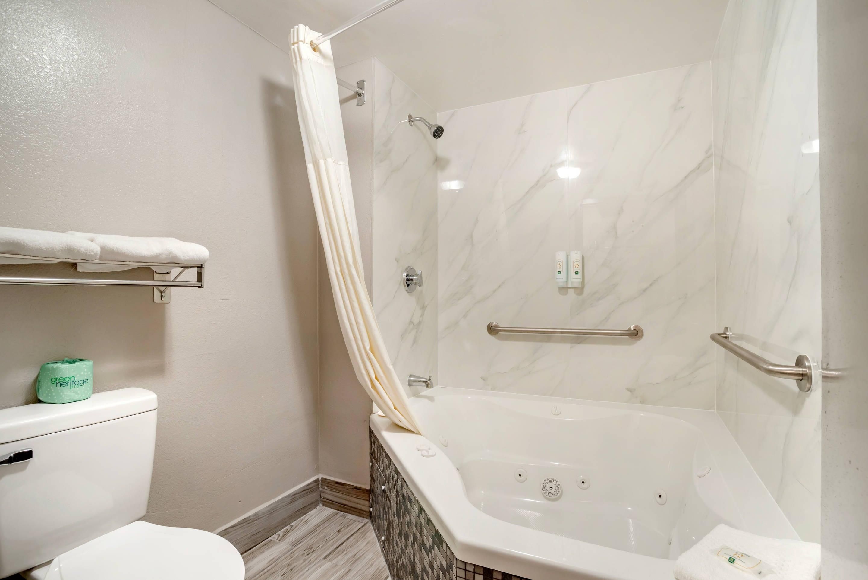 A bathroom with a shower, toilet, and bathtub.