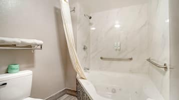 A bathroom with a shower, toilet, and bathtub.