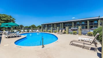 Una piscina al aire libre de temporada, sillones reclinables de piscina