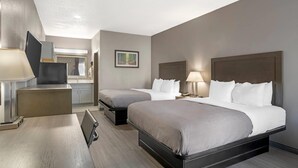 A hotel room with two beds, a desk, a chair, and a small kitchenette. - Quality Inn Simpsonville - Greenville (Simpsonville)