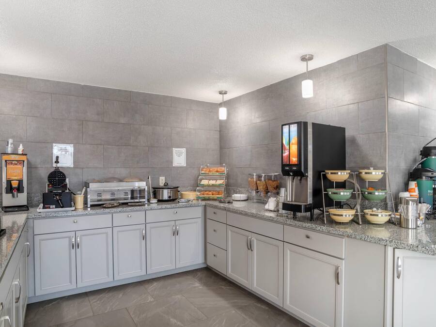 Una cocina moderna con una máquina para gofres, cafetera y barra de desayuno.