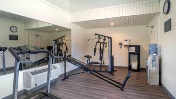 A gym with cardio equipment, weight machines, and a water dispenser.