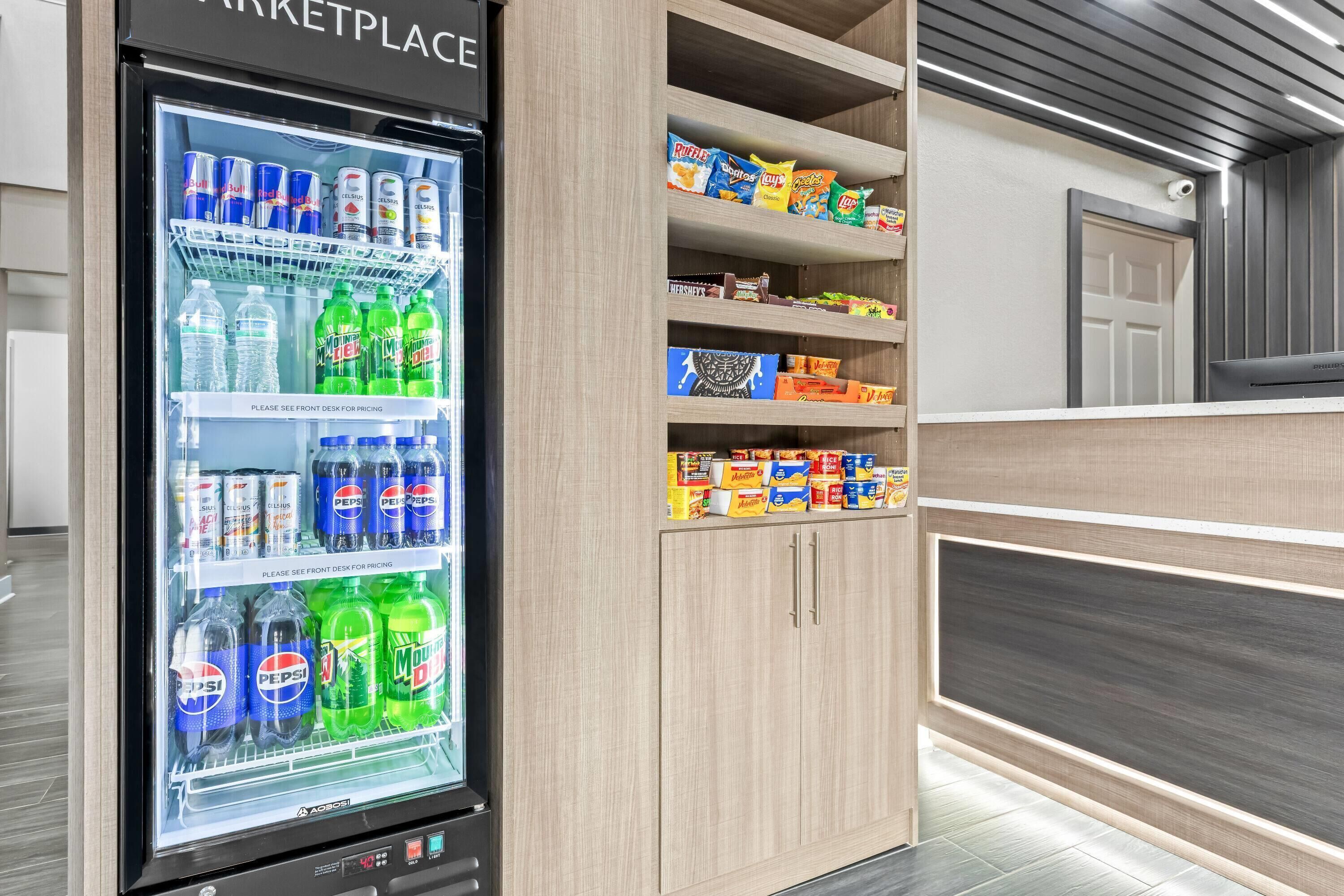 Ein Getränkeautomat mit Pepsi und Mountain Dew, und Regale voller Snacks und Kekse.