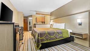 A hotel room with a bed, a TV, a desk, and a bathroom visible through an open door. - Super 8 by Wyndham Athens (Athens)