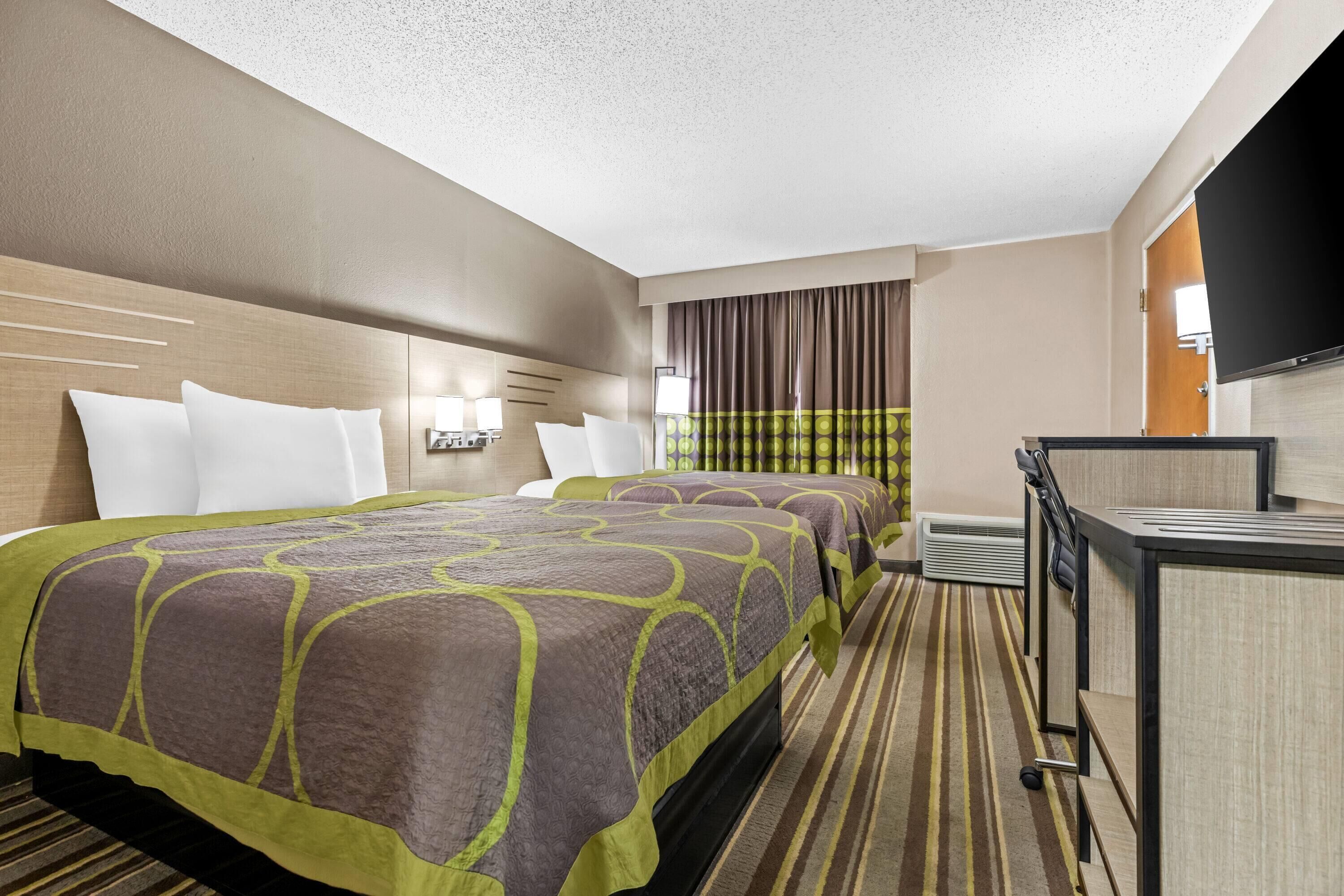Une chambre d’hôtel avec un grand lit, un bureau et une télévision.